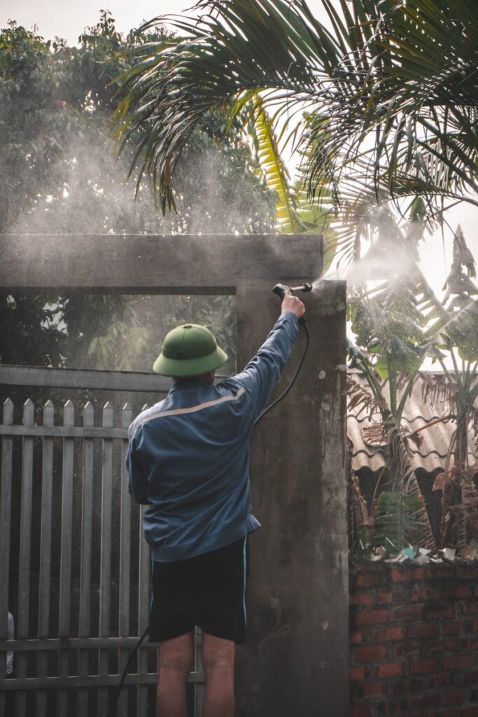 man in blue shirt and blue pants standing near green palm tree during daytime