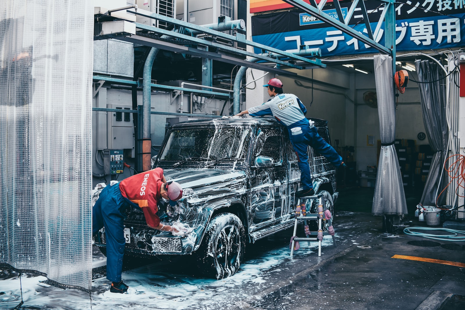 two men washing black SUV