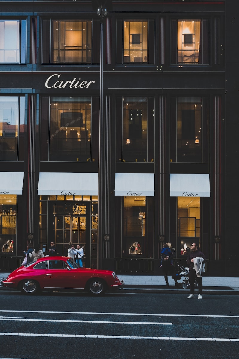 red coupe infront of cartier shop