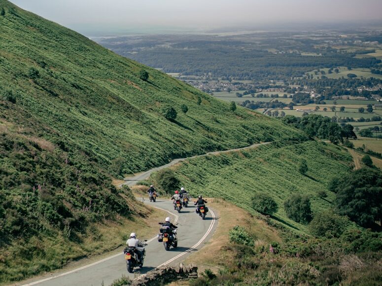 a group of people riding motorcycles down a curvy road