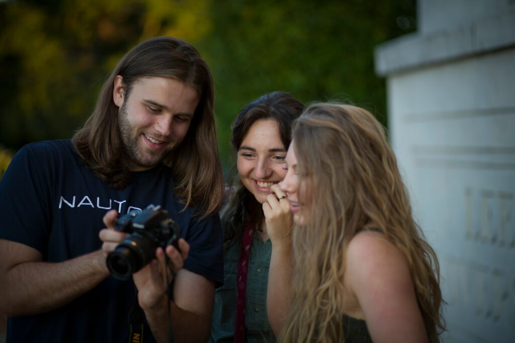 woman in black tank top holding black dslr camera