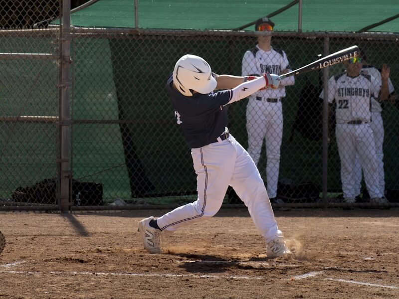 A baseball player swings the bat to hit the ball.