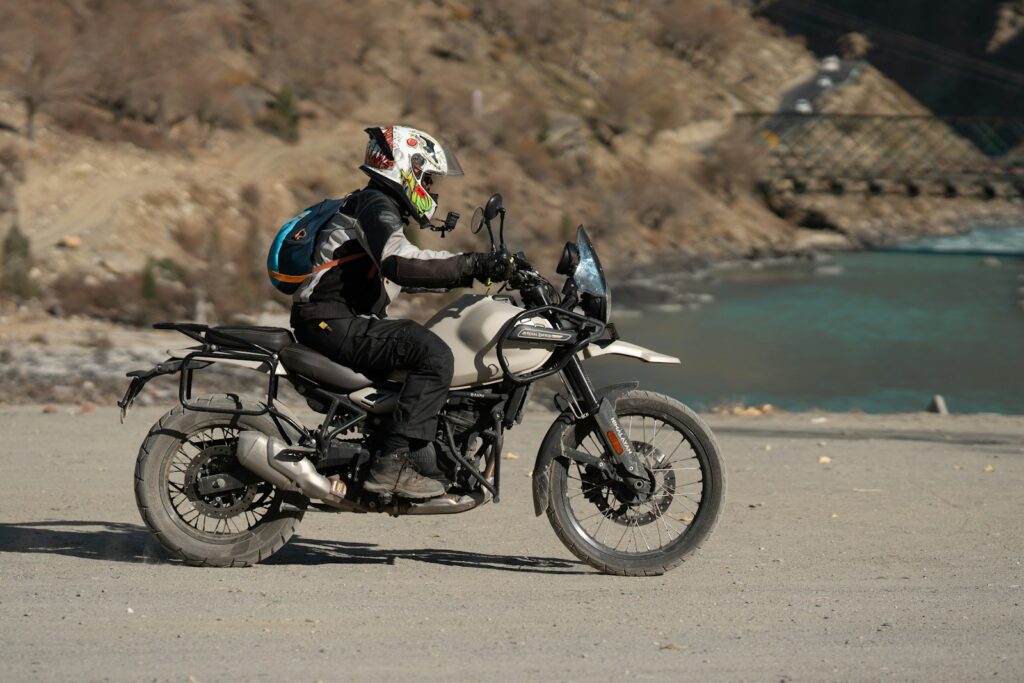 A man riding a motorcycle down a dirt road