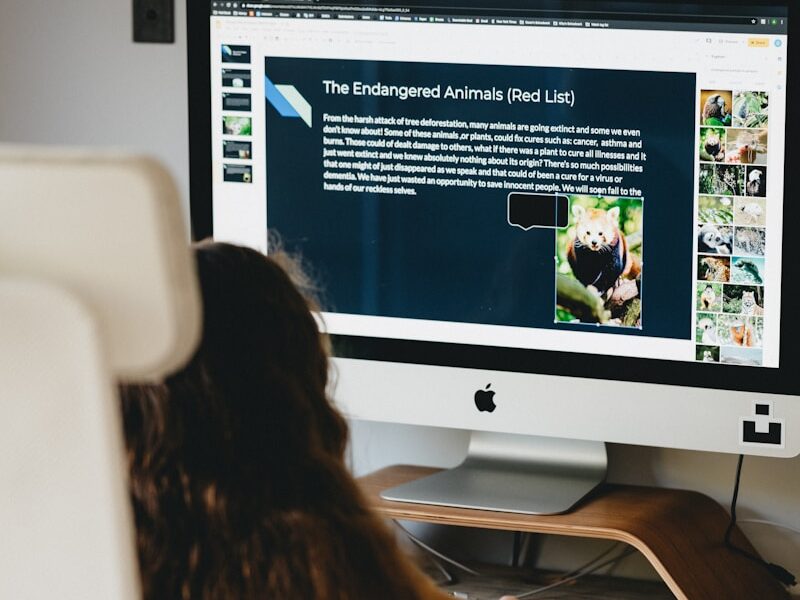 woman in black shirt sitting in front of silver imac
