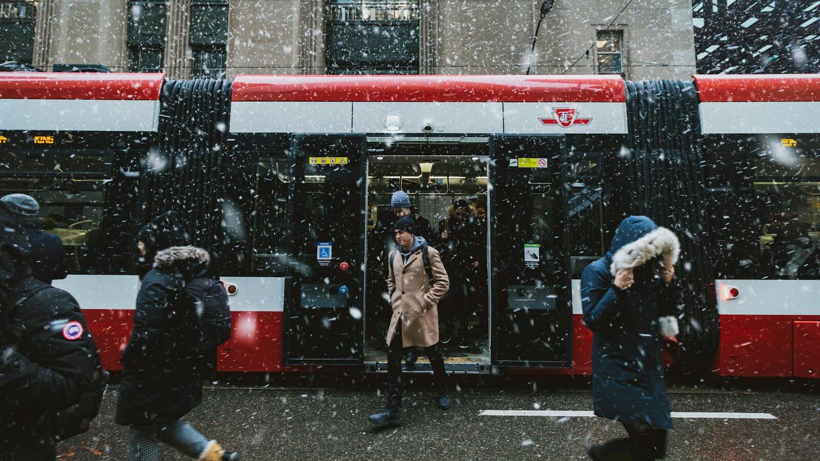 Commuters navigate a snowstorm outside a TTC streetcar in downtown Toronto.