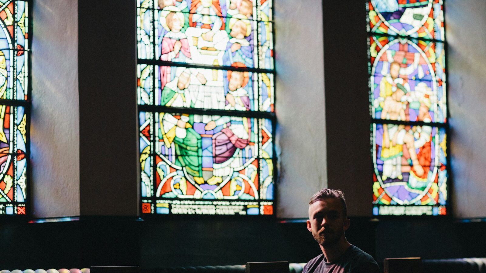 man sitting on pew chair
