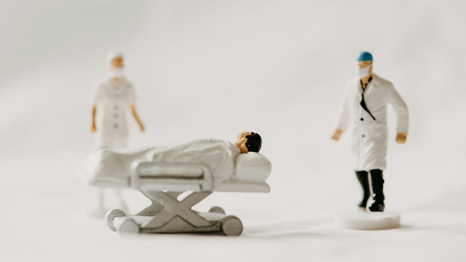 man in white coat and black pants standing beside white wooden picnic table