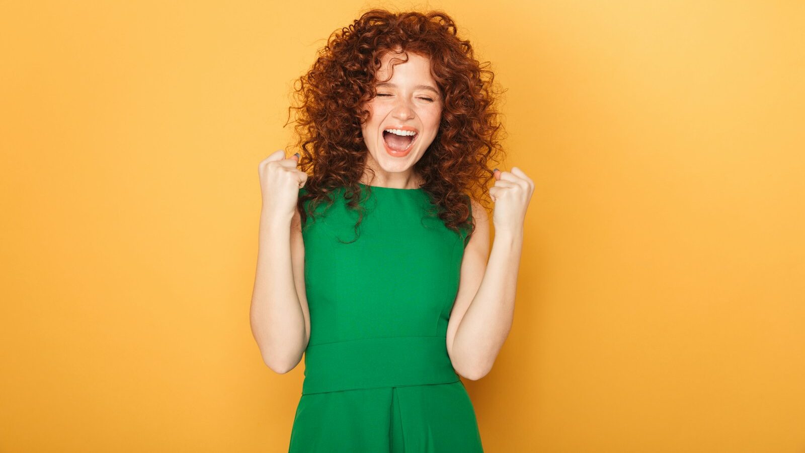 a woman in a green dress is laughing