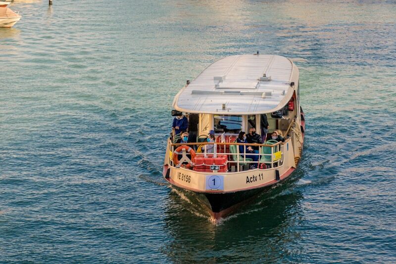 people on boat on water near building during daytime